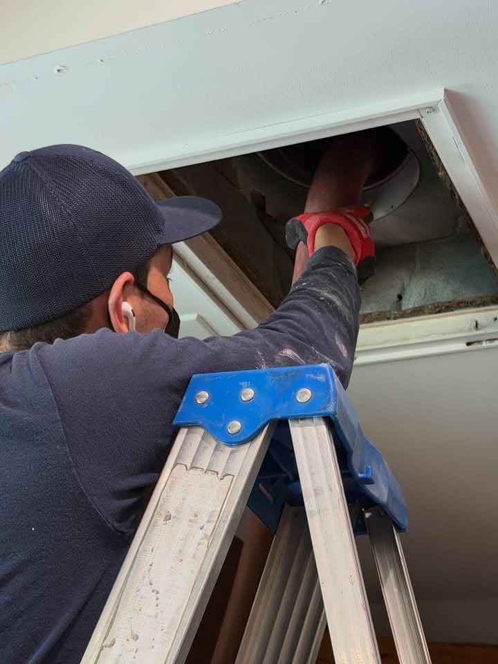 Pristine technician accessing ductwork during service
